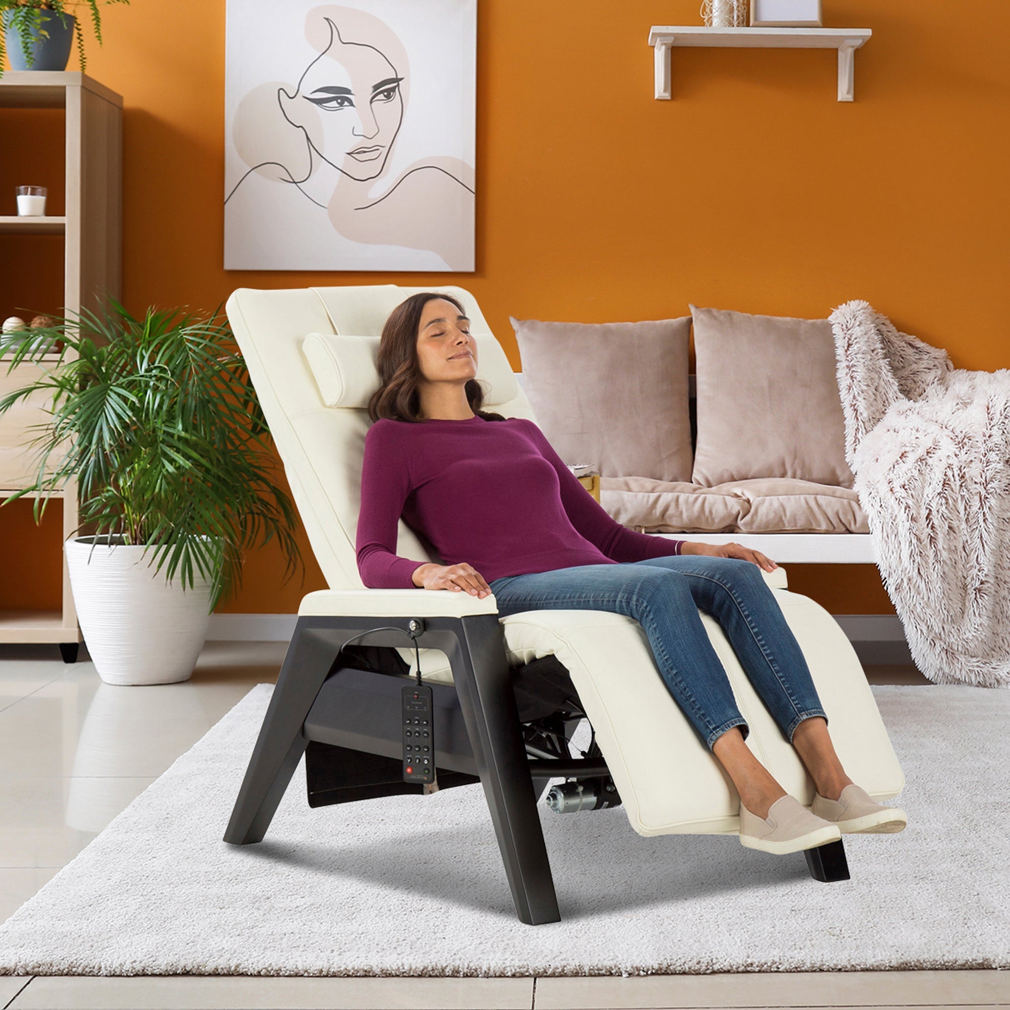 Gravis ZG Chair shown in cream color with person relaxing in zero gravity position against orange wall in modern living room