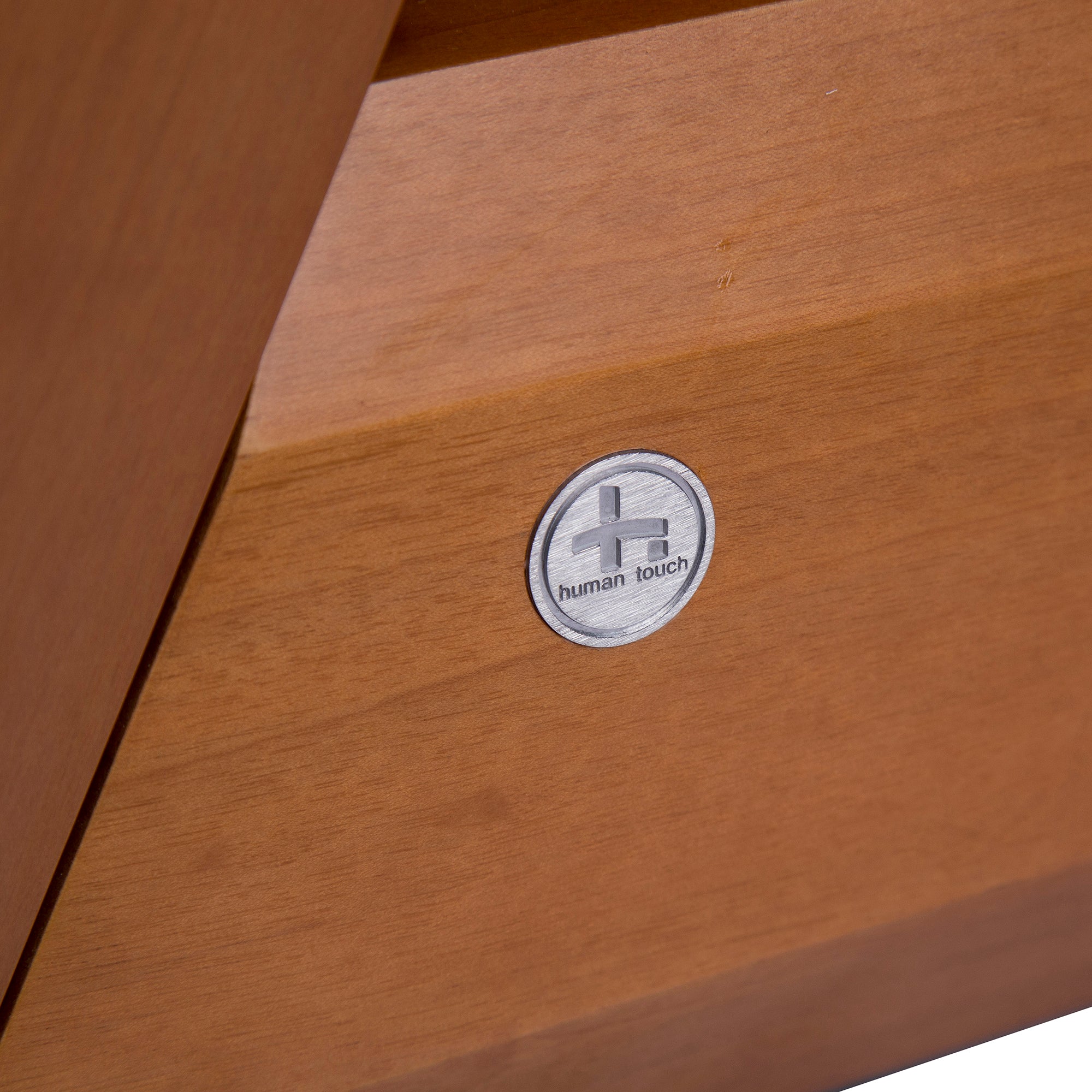 Gravis ZG Chair wooden panel detail with Human Touch logo medallion in brushed silver finish