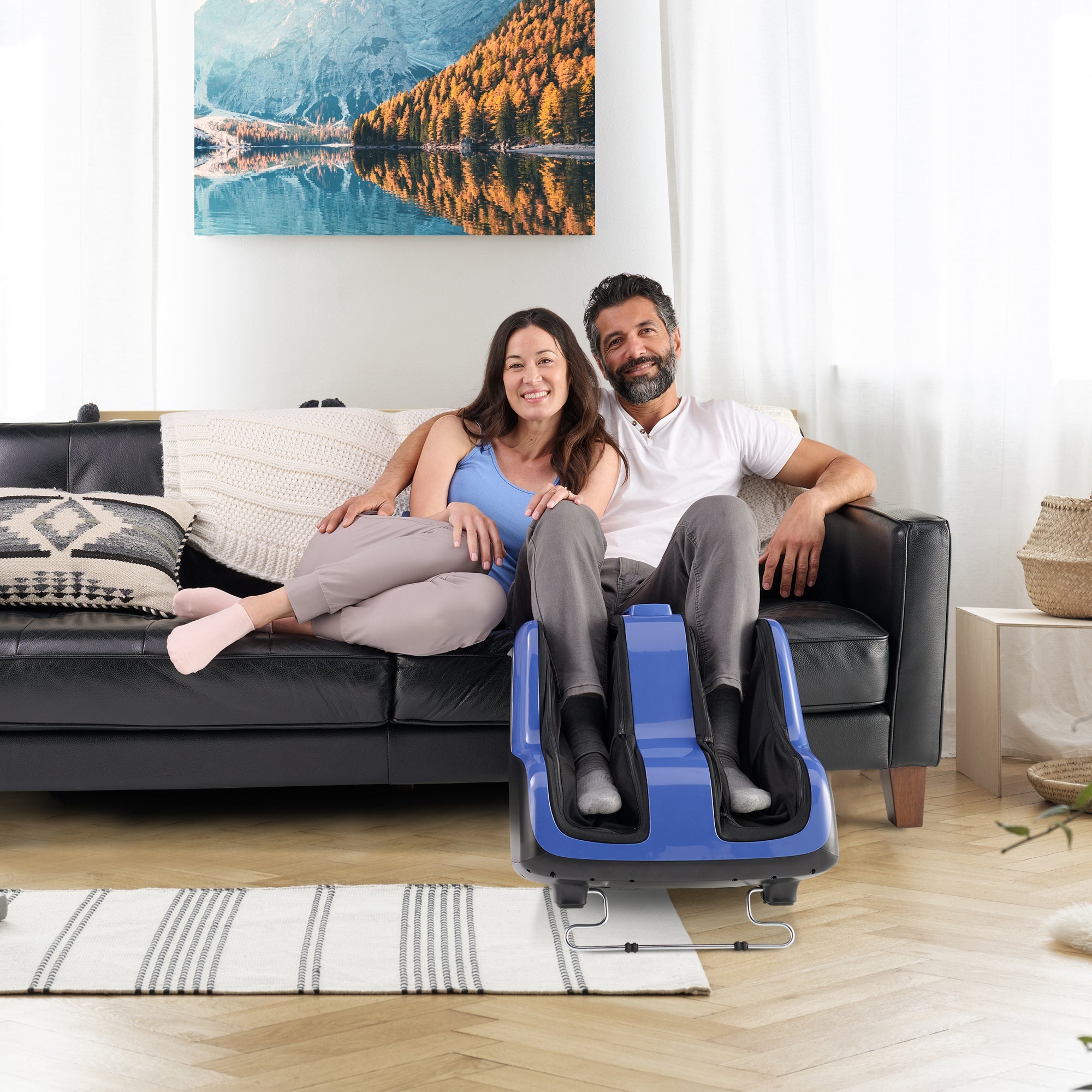 Reflex SOL Plus Foot and Calf Massager shown in blue and black design, displayed in living room setting with couch