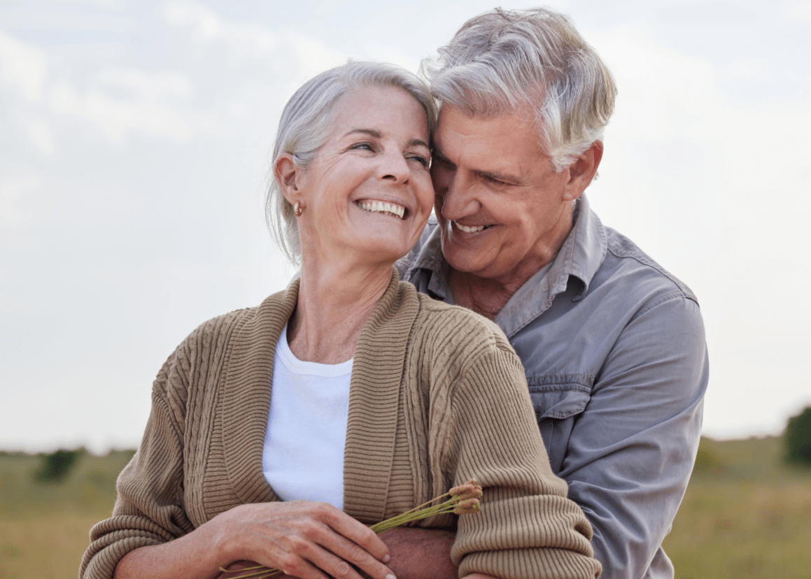 Older couple embracing outside